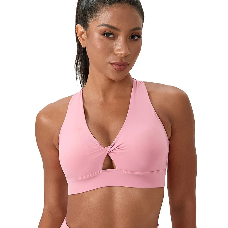 Women's Pink Sports Bra featuring a halter neck and cross back. Twist front detail .