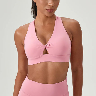 Women's Pink Sports Bra featuring a halter neck and cross back. Twist front detail .